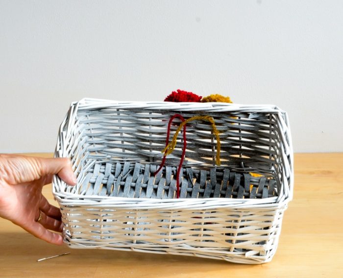 inside of wicker basket showing wool threads from pompom trim